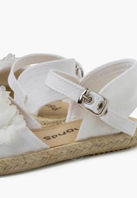Witte canvas sandalen met bloemenaccenten, verstelbare enkelband, jute zool en een textuur bovenkant. De lichte kleur zorgt voor een zachte uitstraling.