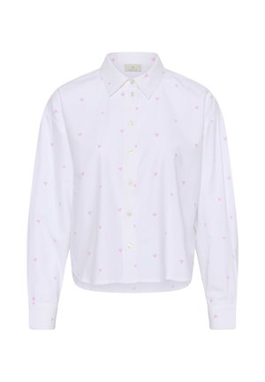 Chemise blanche à manches longues avec col, présentant un motif de petits cœurs roses et une fermeture boutonnée sur le devant. Tissu en coton doux.