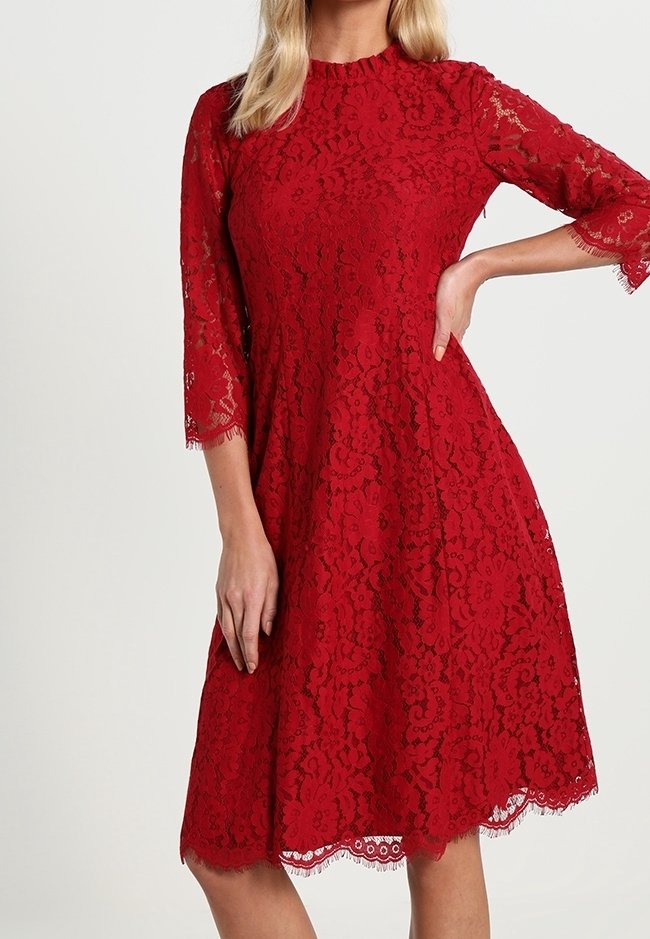 Punainen pitsimekko kolme neljännesosaa hihoilla, aaltoilevalla helmalla, kukkakuviolla ja tiiviillä vartalolla, jossa on läpinäkyvä pitsipinta kauttaaltaan.