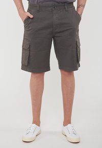 Pantaloni cargo color khaki realizzati in misto cotone, dotati di due tasche laterali, due tasche cargo e chiusura con bottone in vita.