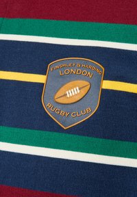 Rugby-Club-Poloshirt mit marineblauem Grund und gestreiften Mustern in kastanienbraun, grün, weiß und gelb. Gesticktes Wappenlogo mit einem Rugbyball-Design.