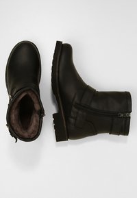 Svarta läderankelstövlar med dragkedja på sidan, mjuk beige foder, texturerad gummisula och sydda detaljer.