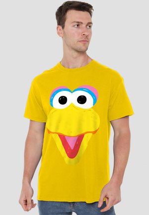 Yellow cotton t-shirt featuring a large cartoon bird face graphic in bright colors, with prominent eyes, a wide mouth, and playful design elements.