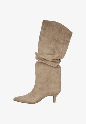 Botín de ante beige con puntera puntiaguda, parte superior arrugada y un bajo tacón estilo kitten, que presenta una textura suave y un diseño sencillo.