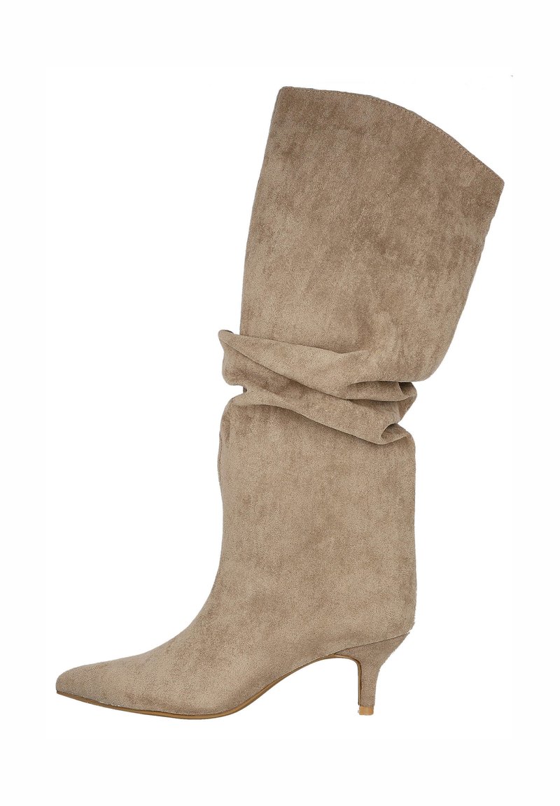 Botín de ante beige con puntera puntiaguda, parte superior arrugada y un bajo tacón estilo kitten, que presenta una textura suave y un diseño sencillo.