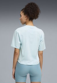 Αθλητική μπλούζα σε ανοιχτό γαλάζιο χρώμα με κοντά μανίκια, στρογγυλή λαιμόκοψη και άνετη εφαρμογή. Λείο ύφασμα με διακριτικές ραφές, συνδυασμένο με ανοιχτό γαλάζιο σορτς.