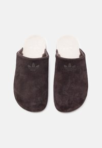 Σκούρα γκρι σουέντ παντόφλες με ανοιχτή φτέρνα, με μαλακό μπεζ πάτο και διακριτικό μαύρο λογότυπο στο μπροστινό μέρος. Ομαλή υφή σε όλη την επιφάνεια.