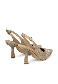 Zapatos de tacón color beige con tiras traseras, con punta afilada, decorados con strass, que cuentan con un acabado texturizado y un diseño de tacón cuadrado.