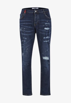 Donkerblauwe slim-fit jeans met versleten stukken en witte verfspatten, voorzien van voorzakken en riemlussen.