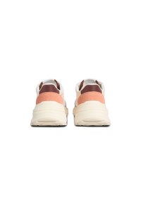 Par de zapatillas bajas con suelas gruesas color crema, con ante rosa y acentos marrón oscuro en el talón, mostradas desde atrás sobre un fondo blanco.