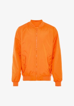 Oranssi pomppupukku, joka on valmistettu sileästä, kevyestä materiaalista. Varustettu etuvetoketjulla, ribbauslahkeilla ja kahdella sivutaskulla.