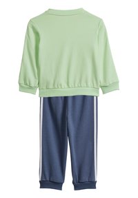 Felpa verde chiaro con polsini a coste, abbinata a pantaloni blu navy con strisce laterali bianche e orlo a coste. Tessuto elasticizzato in cotone misto.