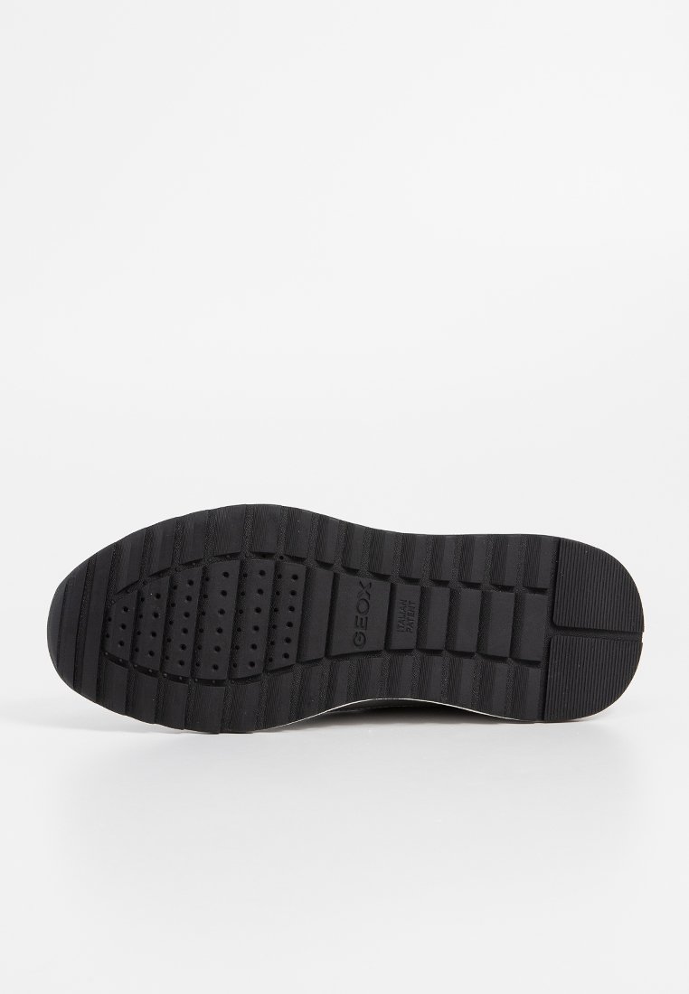 Schwarze Schuhsohle mit gerilltem Profil, durchlöchertem Mittelteil und dem eingeprägten Markennamen "GEOX" in der Nähe des Fußgewölbes.