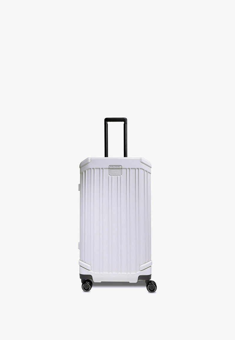 Weißer Hartschalenkoffer mit vertikal geriffeltem Design, schwarzem Teleskopgriff, vier drehbaren Rollen und grauen Akzenten am Boden.