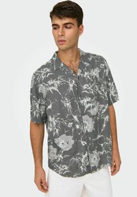 Kurzärmliges Hemd mit Knopfleiste in Dunkelgrau mit weißem Blumenmuster. Leichter Stoff mit lockerer Passform und klassischem Kragen.