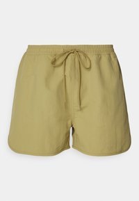 Bañadores de color verde lima con cinturilla elástica, cordón ajustable y tela suave. Presenta aberturas laterales para facilitar el movimiento.