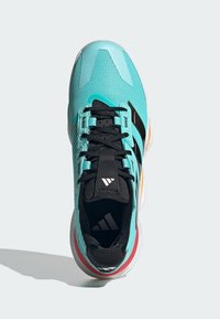 Türkise Sportschuhe mit strukturiertem Obermaterial, schwarzen Schnürsenkeln und drei schwarzen Streifen. Verfügt über eine weiße Laufsohle mit orangefarbenen und roten Akzenten.