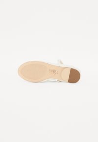 Chaussures blanches au design épuré, avec une semelle en caoutchouc et une touche de beige. Dotées d'une sangle pour un ajustement sécurisé et d'une semelle extérieure striée pour une meilleure traction.