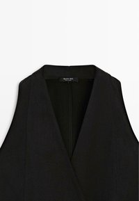 Černá vesta bez rukávů ve stylu saka s širokými klopami a viditelnou štítkem uvnitř límce s nápisem "Massimo Dutti".