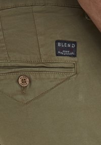 Kháḱove kalhoty s texturovaným povrchem, s nášivkou Blend a dekorativním právkem na zadní kapse.