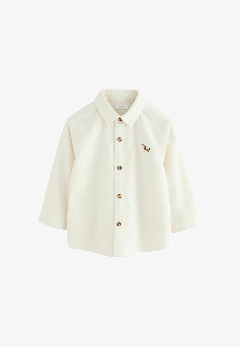 T-shirt crème à manches longues pour tout-petit avec col, devant à boutons et petit teckel brodé marron sur la poitrine gauche.