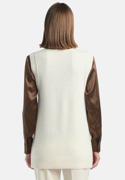 Vest lung, cu nervuri de culoare crem, cu o siluetă ajustată, asortat cu mâneci din satin maro. Material texturat cu un finisaj neted la mâneci.