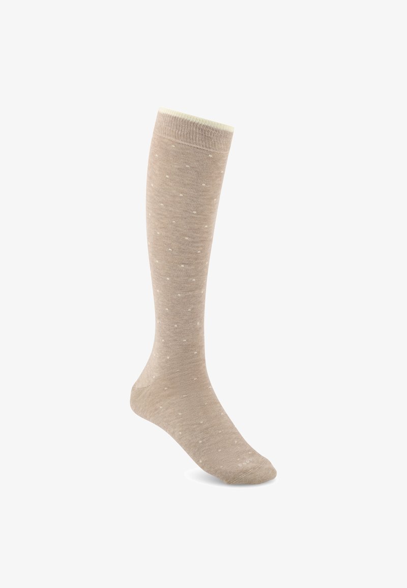 Chaussette beige montant au genou avec un subtil motif de petits points blancs sur un fond blanc uni.