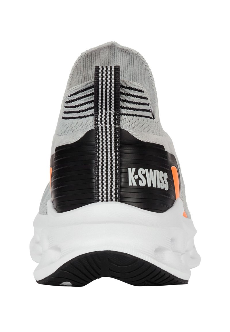 K-Swiss juoksukengät, joissa on harmaa neulottu yläosa, musta kantatuki, oranssit yksityiskohdat ja valkoinen pehmustettu pohja, jossa on karhea pinta.
