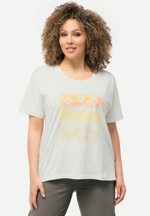 Weißes Baumwoll-T-Shirt mit lässiger Passform. Es hat ein orange-gelbes abstraktes Muster. Die Ärmel sind hochgekrempelt und der Stoff ist weich.