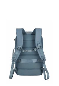 Mochila gris con correas acolchadas, detalles de malla y correas laterales ajustables. Presenta un asa en la parte superior y un diseño de panel trasero organizado.