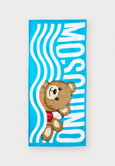 Baby blue towel featuring a cartoon bear wearing a red swimsuit, surrounded by white, wavy lines and the text "MOSQUINO" in bold.