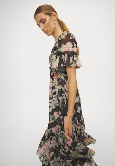 Zwarte bloemenjurk met korte ruches mouwen, een vloeiende silhouet en kantaccenten met roze en groene bloemmotieven overal.