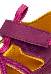 Fioletowe sandały z żółtą podszewką, z teksturowanym paskiem na rzep i różowymi plecionkami. Otwarte palce z miękkim, amortyzowanym wnętrzem.
