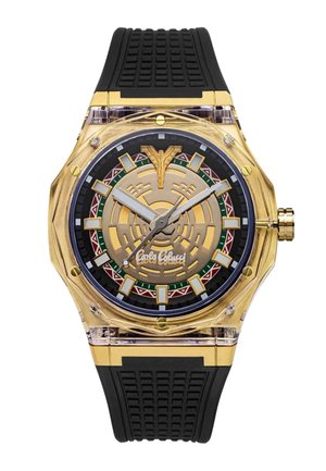 Gold-tone wristwatch with black textured silicone strap, geometric patterned dial, bold hour markers, and distinctive logo at center.