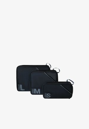 Three black rectangular packing cubes in large, medium, and small sizes, each with a carrying loop and size labels on the front.