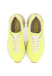 Zapatillas amarillas lima con cordones blancos, con una parte superior texturizada y una suela de goma marrón clara. La marca es visible en la plantilla.