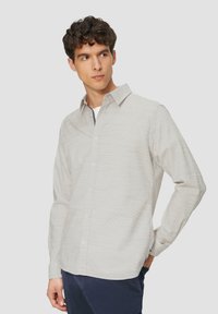 Lichtgrijs shirt met lange mouwen met een subtiel textuurpatroon, button-down kraag en een rechte zoom. G gedragen met navy blauwe broek.