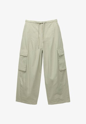 Pantalons cargo vert clair en mélange de coton avec une taille élastique, un cordon de serrage et deux poches cargo latérales. Coupe large et tissu texturé.