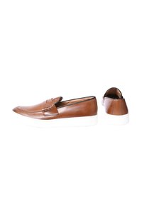 Scarpe slip-on in pelle marrone con punta arrotondata, suola in gomma bianca e cuciture decorative sul collo del piede. Texture liscia con accenti minimi.
