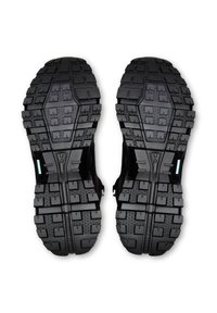 Schwarze Gummischuhsohlen mit tiefem, strukturiertem Profil für besseren Halt, zeigen das "On" Markenlogo und eine strukturierte rutschfeste Oberfläche.