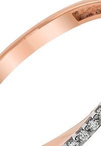 Bague en or rose avec une finition lisse et un design de bande. Accentuée par de petites pierres précieuses claires sur un côté pour créer un contraste.