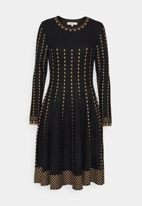 Robe noire à manches longues avec des motifs diagonaux dorés, encolure arrondie, corsage ajusté, jupe évasée et poignets détaillés.