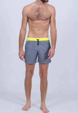 Shorts de bain pour hommes en bleu marine avec un motif géométrique, dotés d'une taille élastique jaune vif et d'un cordon de serrage, fabriqués à partir d'un matériau léger.