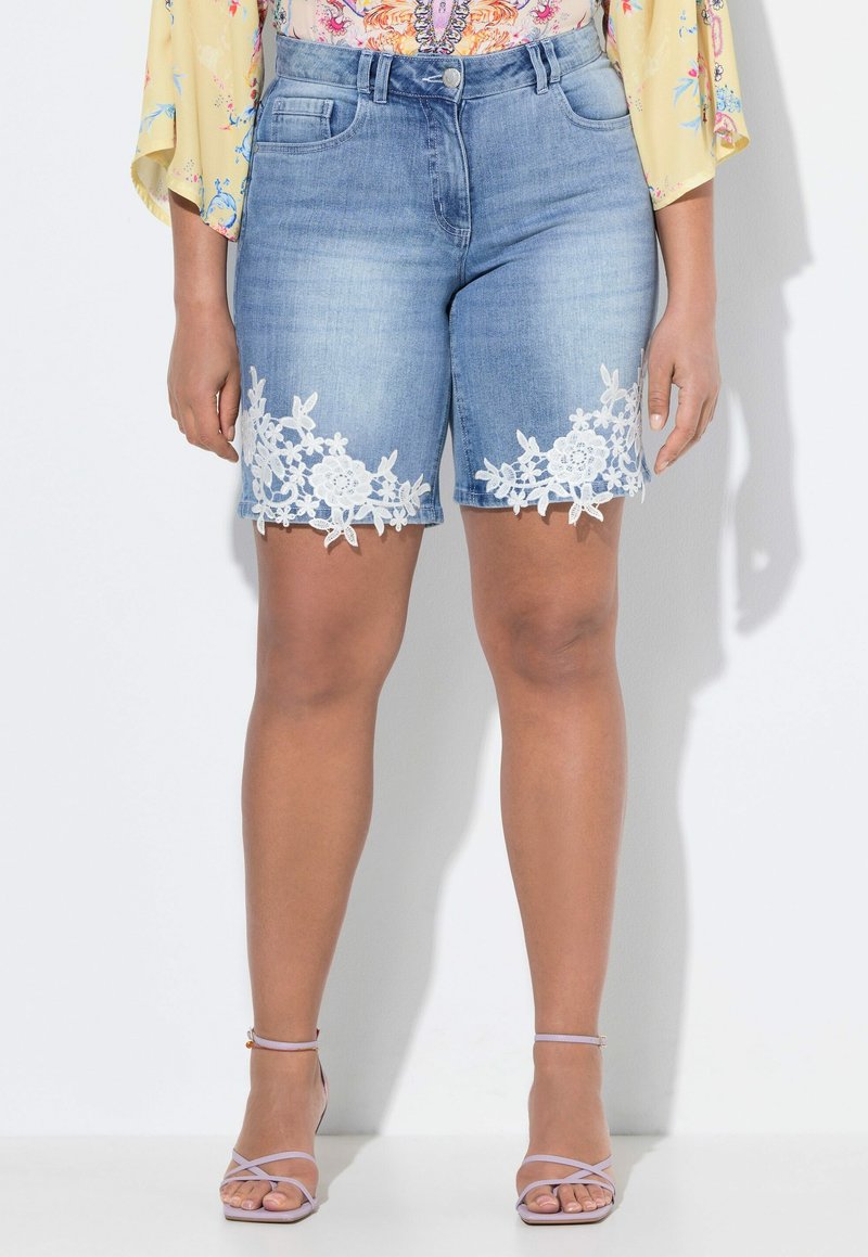 Denim-Shorts in Hellblau mit weißen Blumen-Spitze am Saum. Mit Gürtelschlaufen und frontalen Taschen. Glatte Textur mit geradem Schnitt.