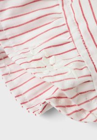 Tessuto di cotone con sottili righe rosse su uno sfondo bianco, con ricami floreali bianchi e dettagli arricciati lungo i bordi.