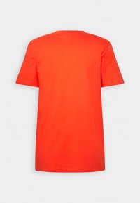 T-shirt uni orange vif à manches courtes et col rond, vu de dos sur un fond gris clair.