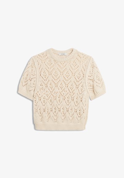 Pull tricoté à manches courtes de couleur crème avec un motif en dentelle en forme de losange et un col, des poignets et un ourlet côtelés.