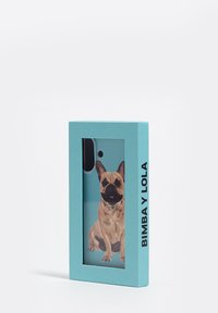 Funda de teléfono en embalaje turquesa con una ilustración de un Bulldog Francés beige sobre un fondo azul claro, con recortes para la cámara y los botones.