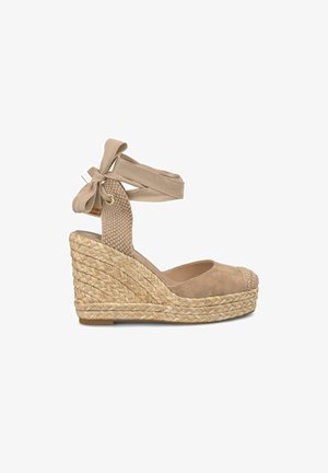 Beige Wildleder Wedge-Espadrilles mit geflochtenem Jute-Absatz, Knöchel-Bändern und einer abgerundeten Spitze, die mit einem geflochtenen Detail versehen ist.