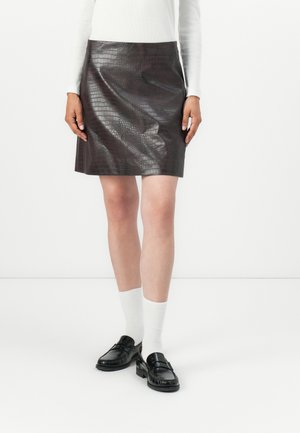Brown faux leather skirt with a crocodile texture, straight cut, and mid-thigh length, paired with black loafers and white socks.